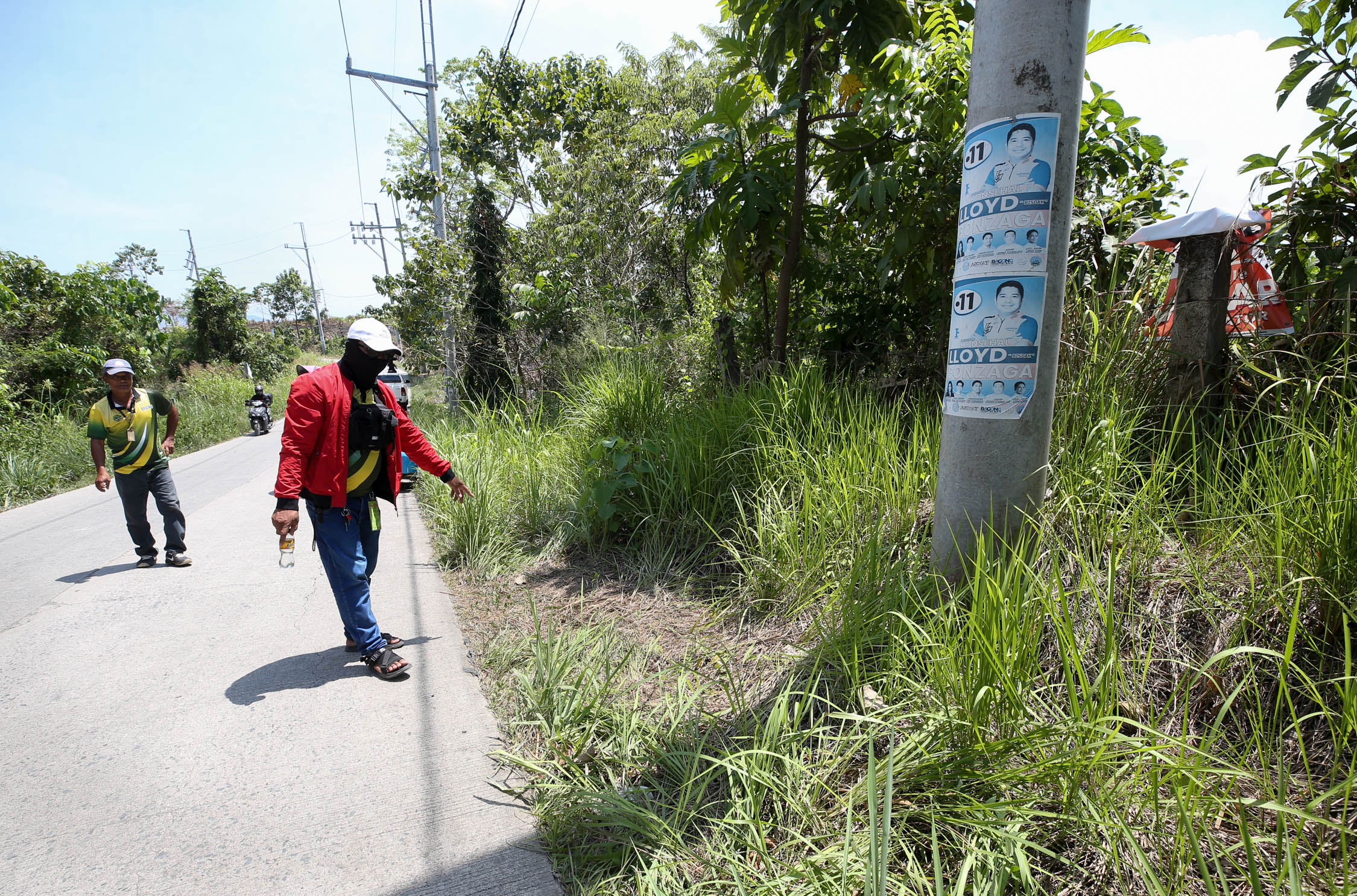RECOVERED BY THE ROADSIDE A barangay employee points to the site in Sitio Odiongan, Barangay Macabud, Rodriguez, Rizal, where the bodies of Chinese-Filipino businessman Anson Que andhis driver Armanie Pabillo were found on Wednesday. They were placed inside nylon bags. The two men were last seen on March 29 after leaving their office in Valenzuela City. 