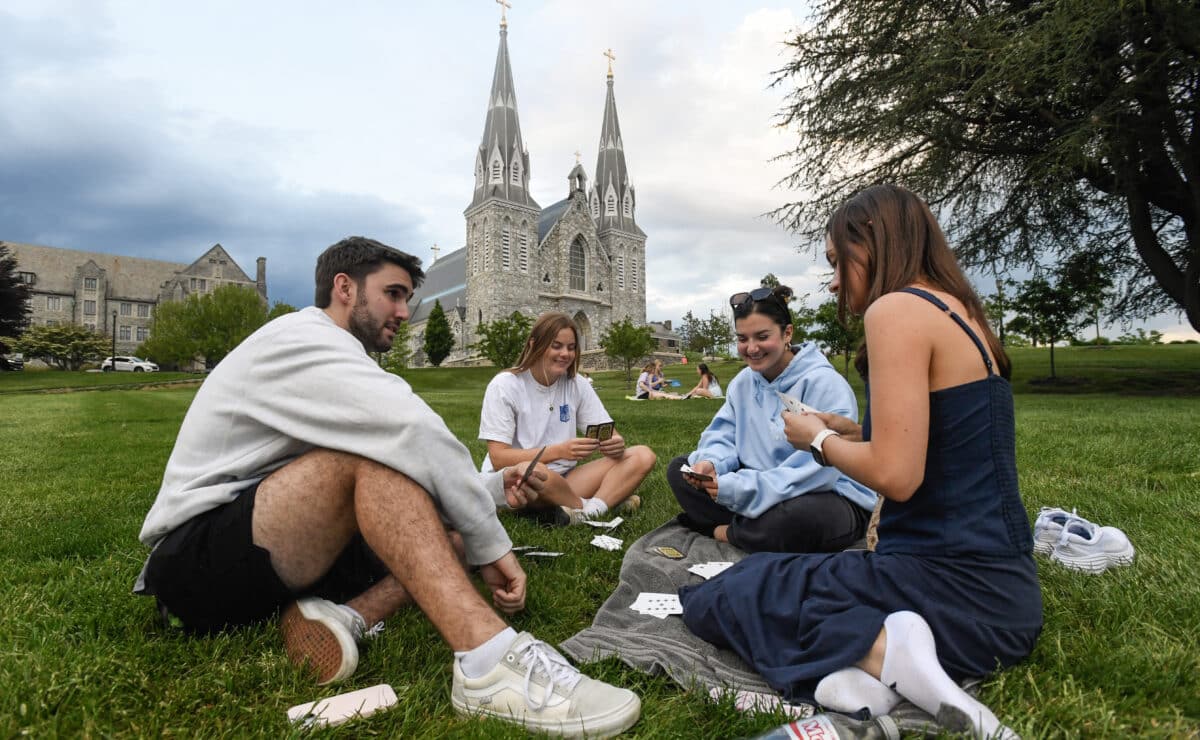 Students play cards outside of St. Thomas of Villanova Church at the campus of Villanova University in Villanova, Pennsylvania on May 8, 2025. Church bells rang as Robert Francis Prevost, a Villanova 1977 graduate, was elected the first pope from the United States on May 8, 2025, picking the papal name Leo XIV. — Photo by Agence France-Presse